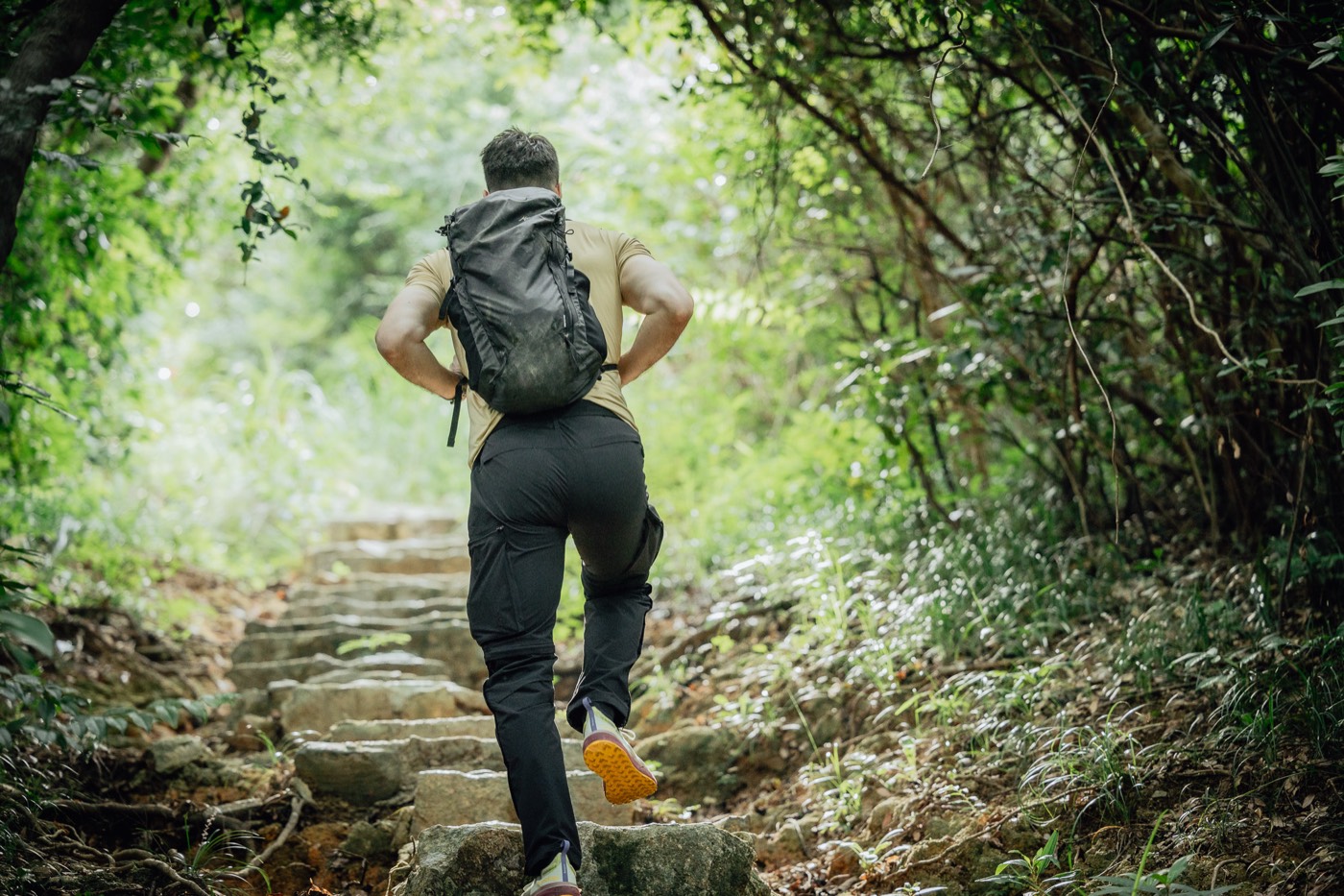 Climbing a forest trail in All Rounder Adventure, seen from behind.